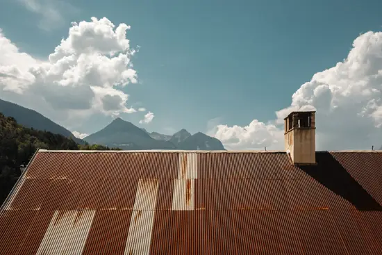 Nuages, ciel bleu, montagnes, toit rouillé et cheminée / France (2025)