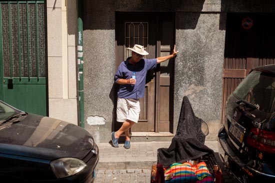 Appuyé devant la porte, chapeau sur la tête, une bouteille à la main / Portugal (2019)